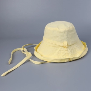 Detailed texture of light yellow cotton sun hat with adjustable chin strap for women