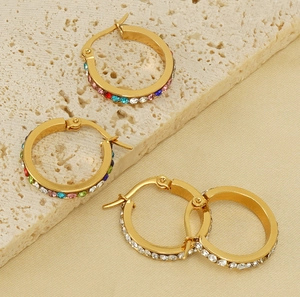 Close-up of gold stainless steel hoop earrings featuring white and colorful rhinestones