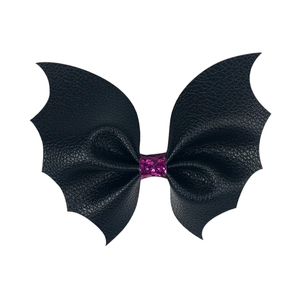 Detail of black faux leather bat wing hair clip with pink glitter center for Halloween
