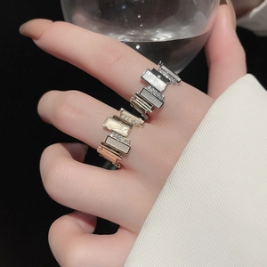 Close-up of geometric silver and rose gold rings with cubic zirconia and mother of pearl