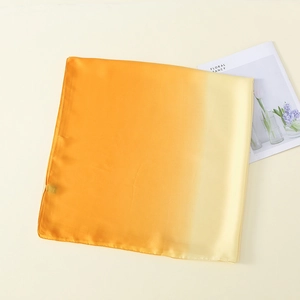 Details eines Seidenschals mit Farbverlauf von Tiefgold zu hellem Beige-Satin