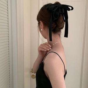 Elegant black fabric bow hair claw clip styled in a sophisticated French twist hairstyle