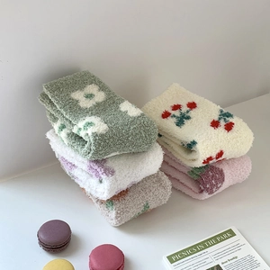 Detail of coral fleece socks showing soft fluffy texture and colorful floral embroidery