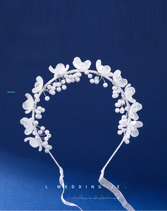 Detail of white matte floral headband with pearl beads and silk ribbons for flower girls