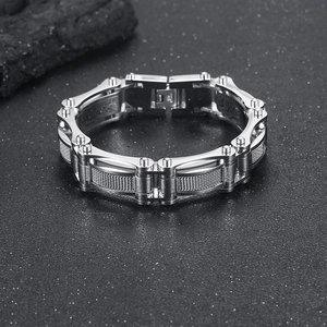 Vue macro d'un bracelet industriel en acier argenté avec détails de maille texturée