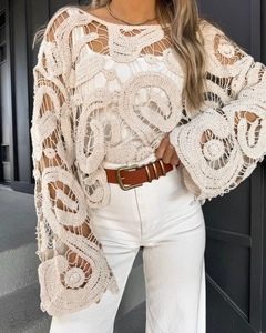 Detailed close-up of bohemian hollow crochet floral pattern and lace sleeve texture