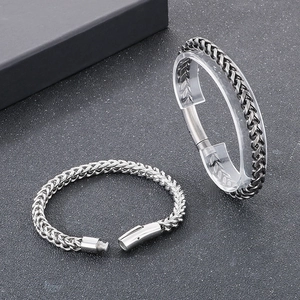 Close-up of chunky stainless steel curb chain bracelet with secure plug-in buckle