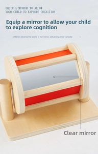 Close-up of wooden Montessori spinning drum with red panels and safety mirror for babies