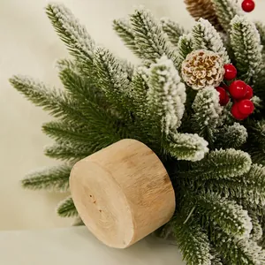 Mini artificial Nobel Fir Christmas tree with snow, berries, and a natural wood base