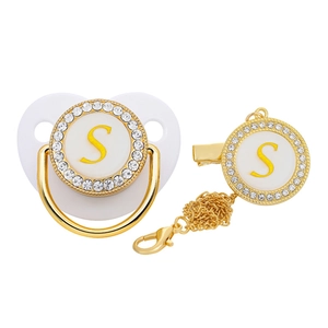 Detail of baby pacifier set with golden letter S and sparkling rhinestone accents