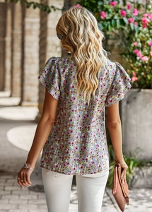 Detail of floral printed top showing ruffled short sleeves and feminine blue pattern