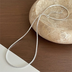 Detail of a sparkling sterling silver tennis necklace with zircons on a marble tray