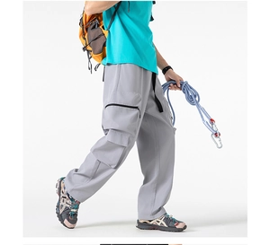 Dettaglio dei pantaloni cargo grigio chiaro con tasche multiple e coulisse in vita