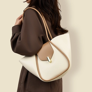 Détail du sac à bandoulière minimaliste en cuir crème et marron avec fermoir doré
