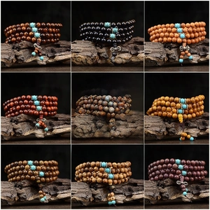 Vue détaillée des perles de prière bouddhistes en bois avec accents turquoise et charms vajra