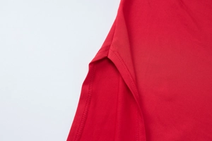Gros plan détaillé de la double couture et de la fente latérale sur robe rouge