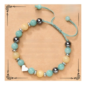 Detail of adjustable woven bracelet with multi-color beads and silver heart charm on card