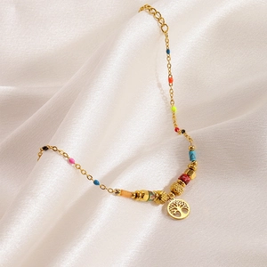 Detailed close-up of golden Tree of Life charm bracelet with vibrant multicolor beads