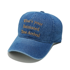 Close-up of brown embroidery on washed blue denim baseball cap with detailed stitching
