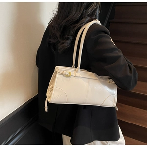 Detail of cream-white leather shoulder bag with metallic buckles and dual straps