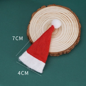 Close-up of 7x4cm mini red and white knitted Christmas hat on a rustic wood slice