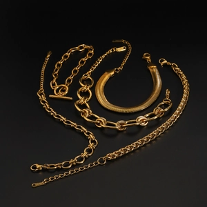 Detailed flat lay of five assorted gold plated stainless steel necklaces and bracelets