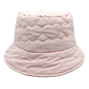 Detail of light pink bucket hat showing intricate heart-shaped quilted pattern and texture