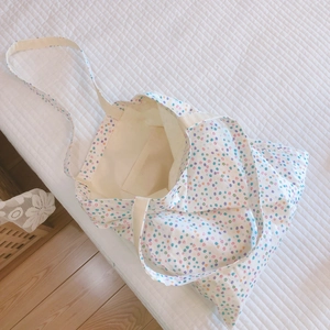 Detail einer floralen Baumwoll-Tasche mit bunten Punkten auf weißem Stepp-Hintergrund