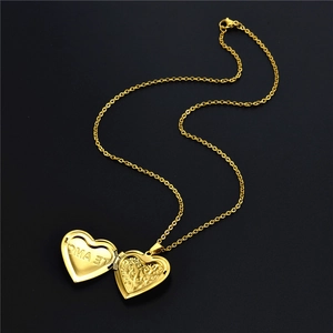 Golden heart locket necklace with Te Amo engraving shown open on a black background
