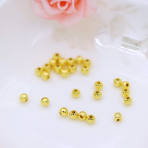 Close-up of polished 18K gold-plated beads with center holes for DIY jewelry making