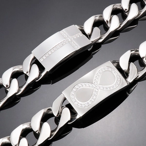 Gros plan d'un bracelet gourmette en acier titane argenté avec croix et infini sertis de diamants
