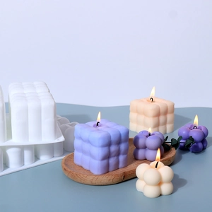 Détail macro du moule en silicone pour bougie bulbe avec bougies blanches et violettes
