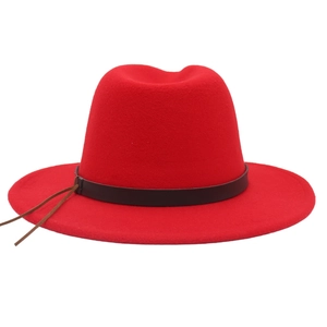 Detailed close-up of a red wool fedora hat featuring a wide brim and brown leather band
