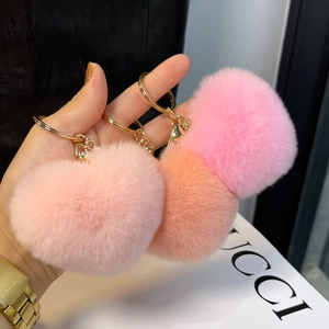 Detail of pink and peach heart-shaped faux fur keychains with golden metal ring clips
