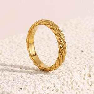 Detail of classic gold plated stainless steel ring with elegant twill pattern on stone
