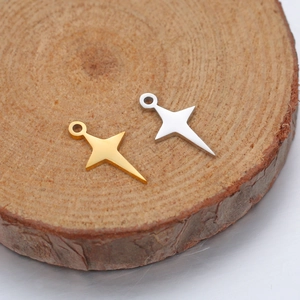 Polished stainless steel star pendants in gold and silver on a rustic wood slice