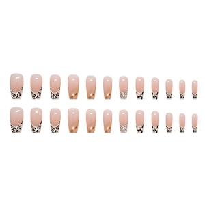 Faux ongles French avec motif de vache et base rose sur fond blanc pur