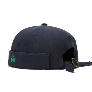 Navy blue canvas docker hat with green clover embroidery and adjustable bronze buckle