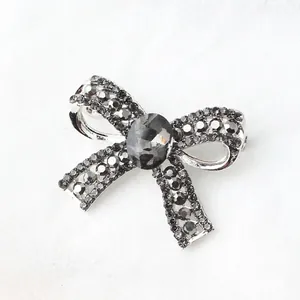 Sparkling silver bow brooch with grey rhinestones for suits and elegant outfits