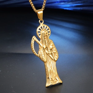 Detailed close-up of golden Santa Muerte pendant with scythe and scales on a gold chain