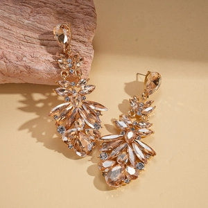 Detail of luxury drop earrings with champagne crystal droplets and gold metal base