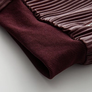 Close-up of burgundy vintage faux leather jacket with ribbed cuffs and metal zipper