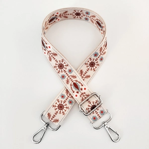 Detail of adjustable beige woven strap with red and blue ethnic patterns and silver hooks