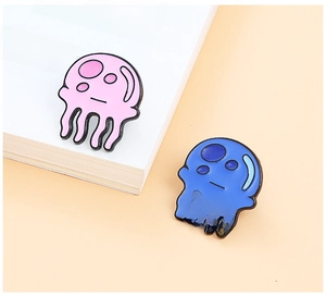 Close-up of cute pink and blue jellyfish enamel pins on a soft beige background