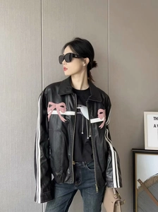 Détail du blouson noir en cuir PU avec nœuds roses et rayures blanches sur manches