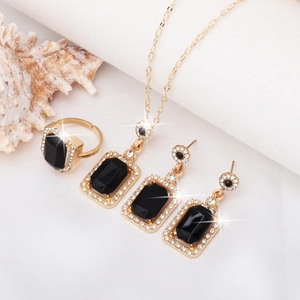 Elegant gold jewelry set with emerald green stones and diamonds on a white shell