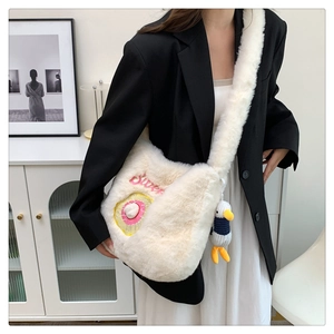 Detail of plush shoulder bag with Sweet embroidery and cute duckling pendant charm