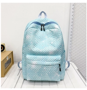 Detalle de mochila acolchada azul claro con patrones de corazones blancos y cremalleras