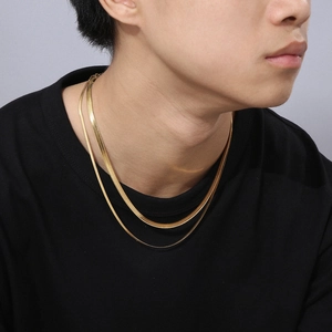 Close-up of double-layer flat snake bone chain necklace in 18k gold on a model