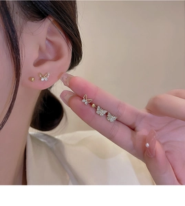 Macro shot of gold butterfly earrings set with sparkling cubic zirconia on ears